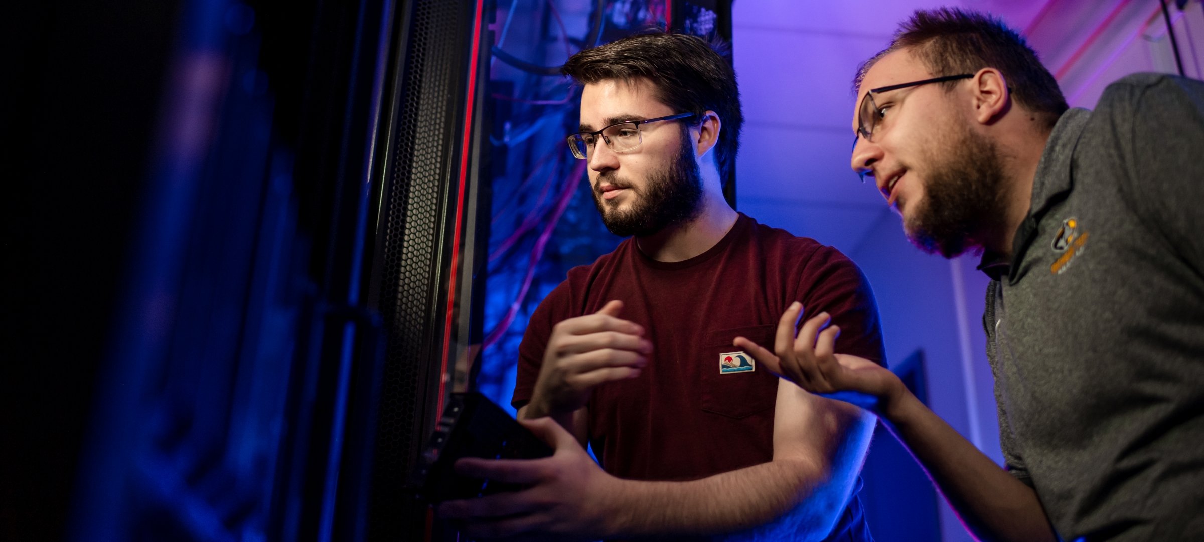 Two graduate students interacting inside a server in the Security / Network / Programming Lab