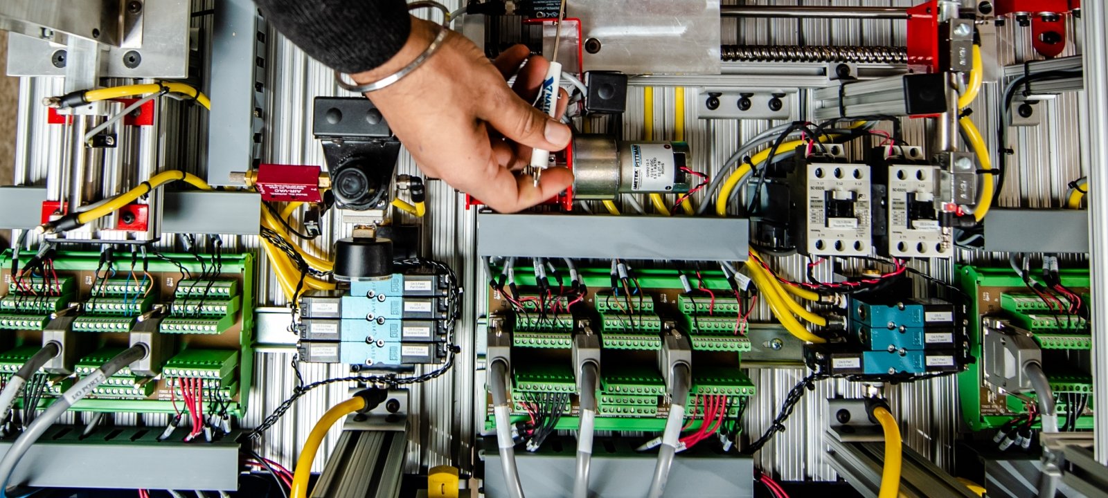 A hand adjusting electronics in the robotics lab