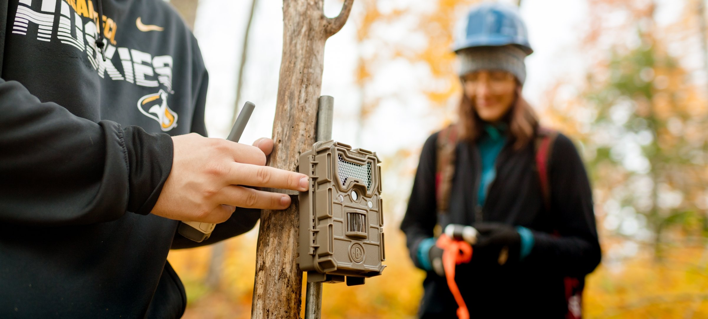 Forestry students use camera traps in the woods in fall.