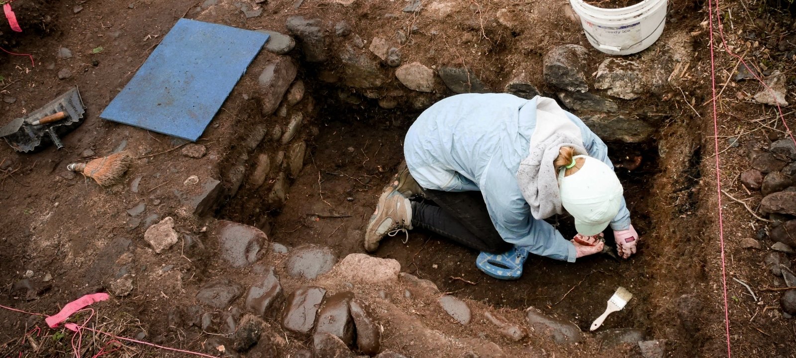 Industrial Archaeology student working in a rectangular dig site.
