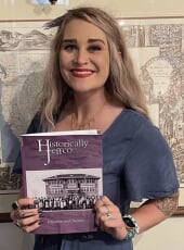 Kayla Gabehart, a white woman with blonde hair holding a copy of Historically Jeffco magazine.