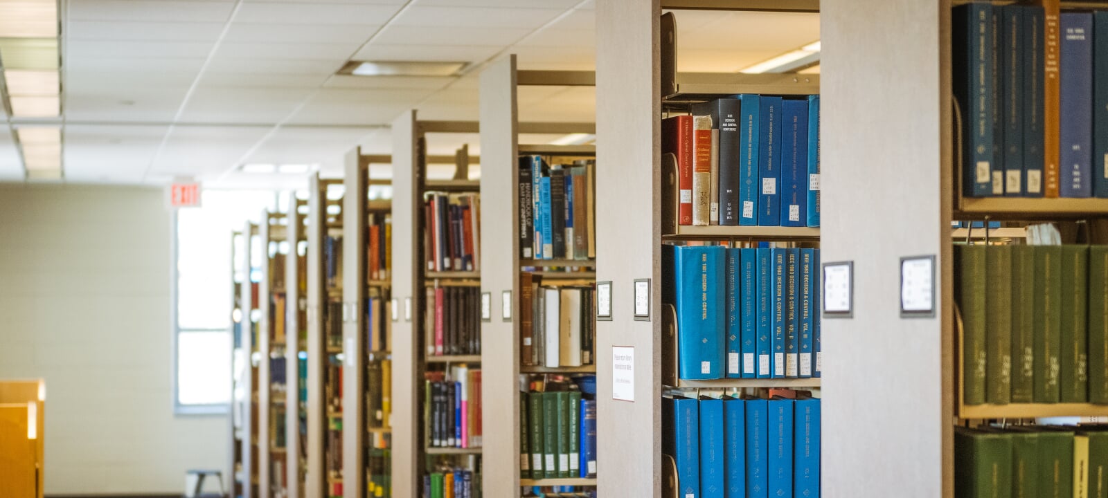 A row of library shelves full of books.