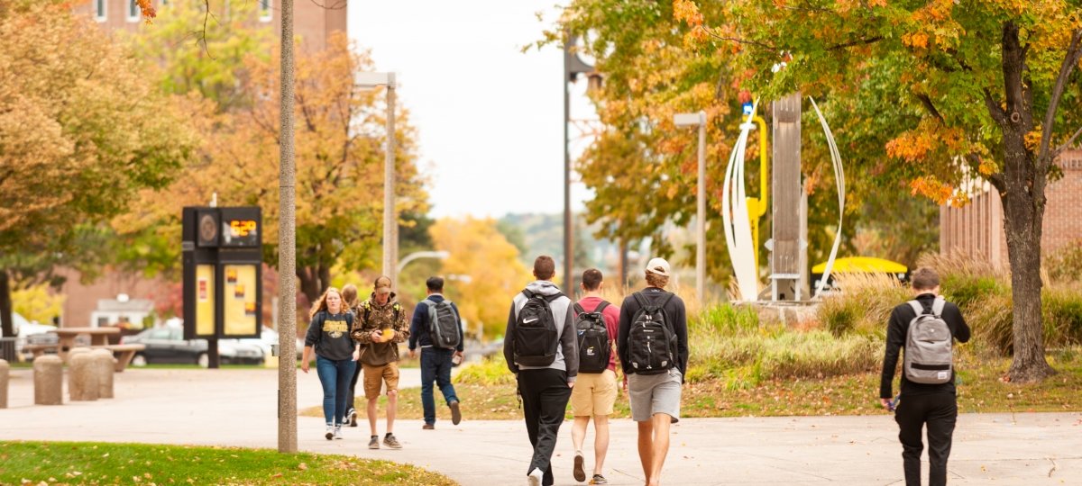 Students on campus talking in the fall