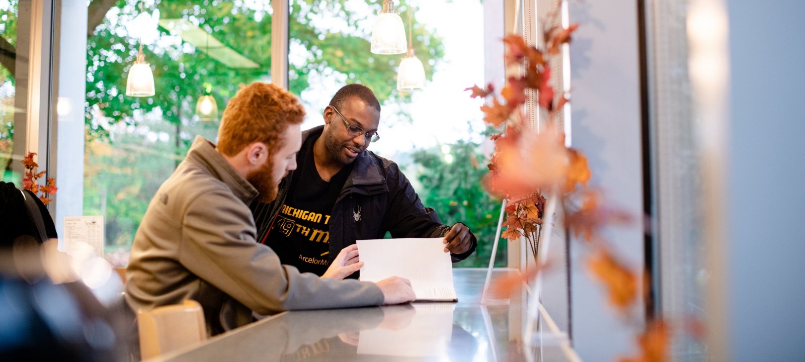 Two graduate students reviewing a document