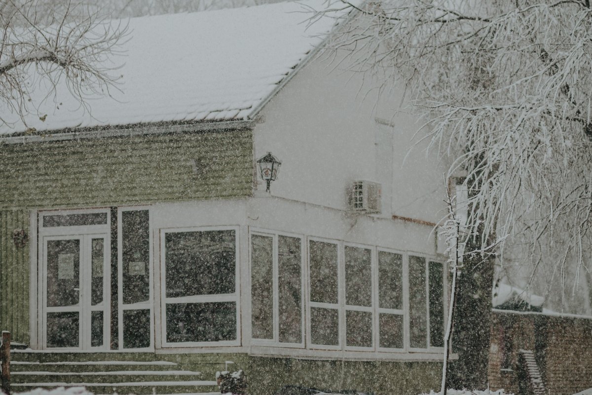Snowing with house in background