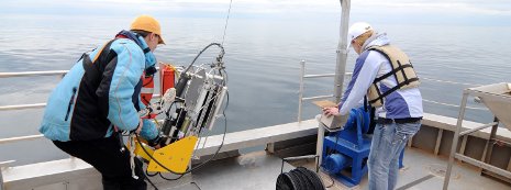 Researchers on the RV Agassiz moving equipment