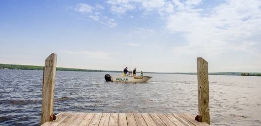 From the dock, the SV Polar floats on the water with three researchers