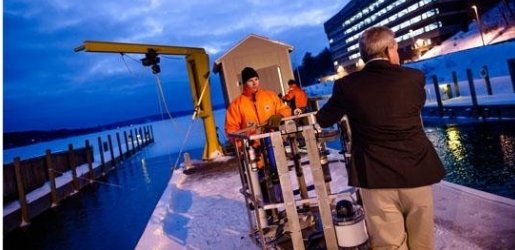 Two researchers move equipment on the dock of the GLRC on a winter's evening.