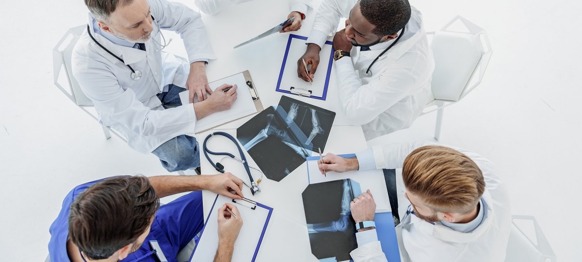 A group of doctors at a table examining x-rays