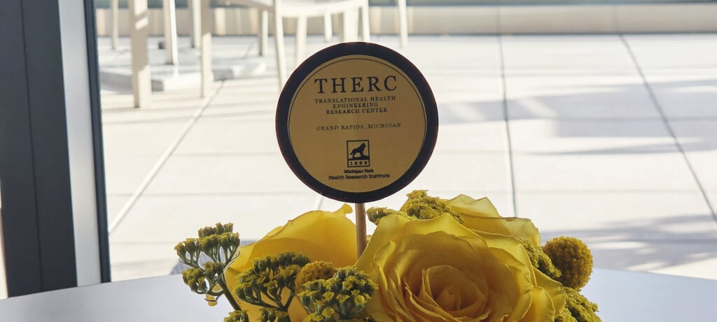 picture of a yellow flowers with a pick sticking out with the THERC logo