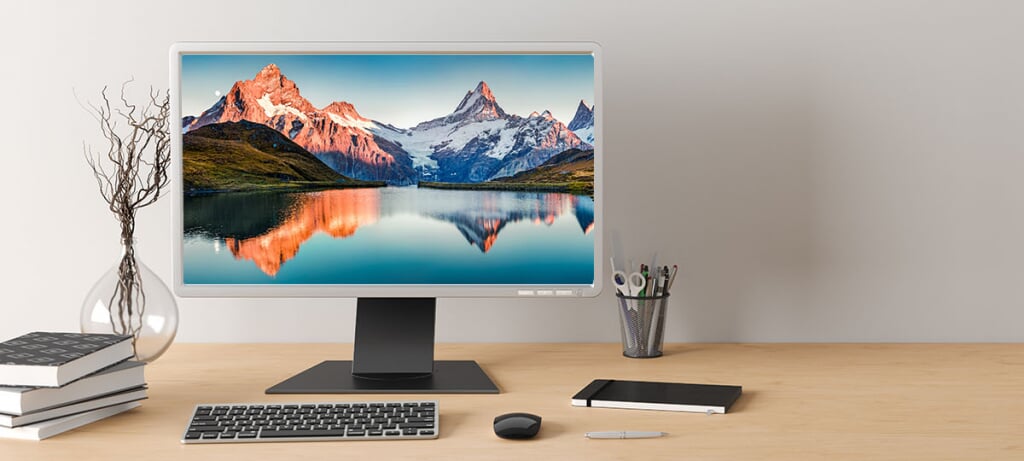 picture of desk with a computer, keyboard, and other stationary supplies