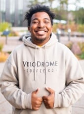 Student, Chris, in hoodie standing outside with two thumbs up