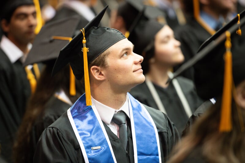 Students at Commencement looking up at the viewer in the Ice Areana