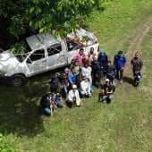 drone view of a group of people standing next to a white truck