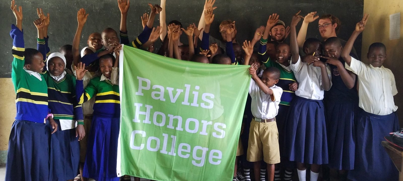 Students holding a Pavlis Honors College flag