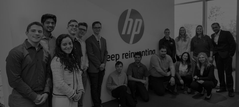 A group of students posing in front of the HP corporate headquarters