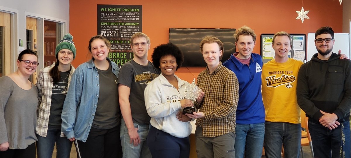 Members of the Undergraduate Student Advisory Board pose with a Winter Carnival statue trophy