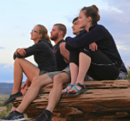 Four students sitting on a cliff.