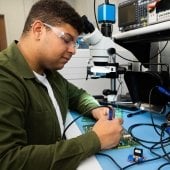 Student working on a circuit board.