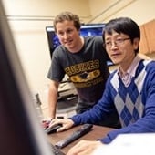 Faculty and student looking at a computer.