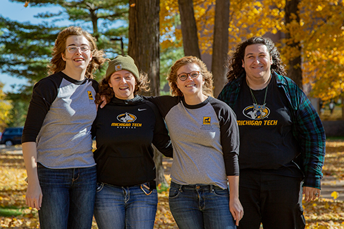 Four Residential Assistants posing in front of fall colors