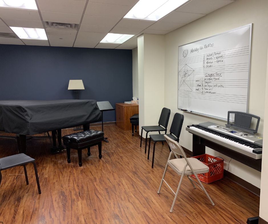 A view of the room from the entrance, showing the keyboard, piano and chairs