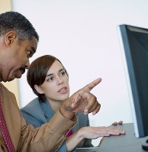 Two people looking at a computer screen.