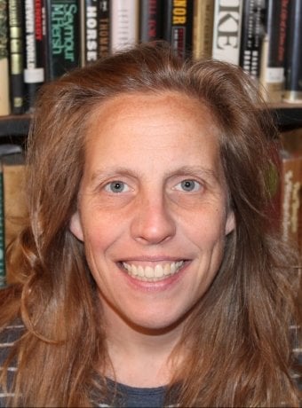 Portrait of Holly in front of a shelf of books.