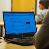 Someone with a laptop on a desk.