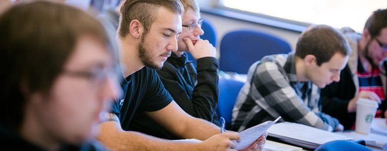 Students sitting in a classroom taking a placement exam.