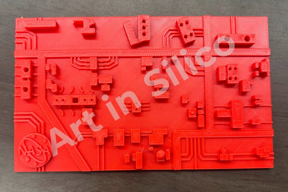 A red 3D printed circuit board with the NASA logo on it.