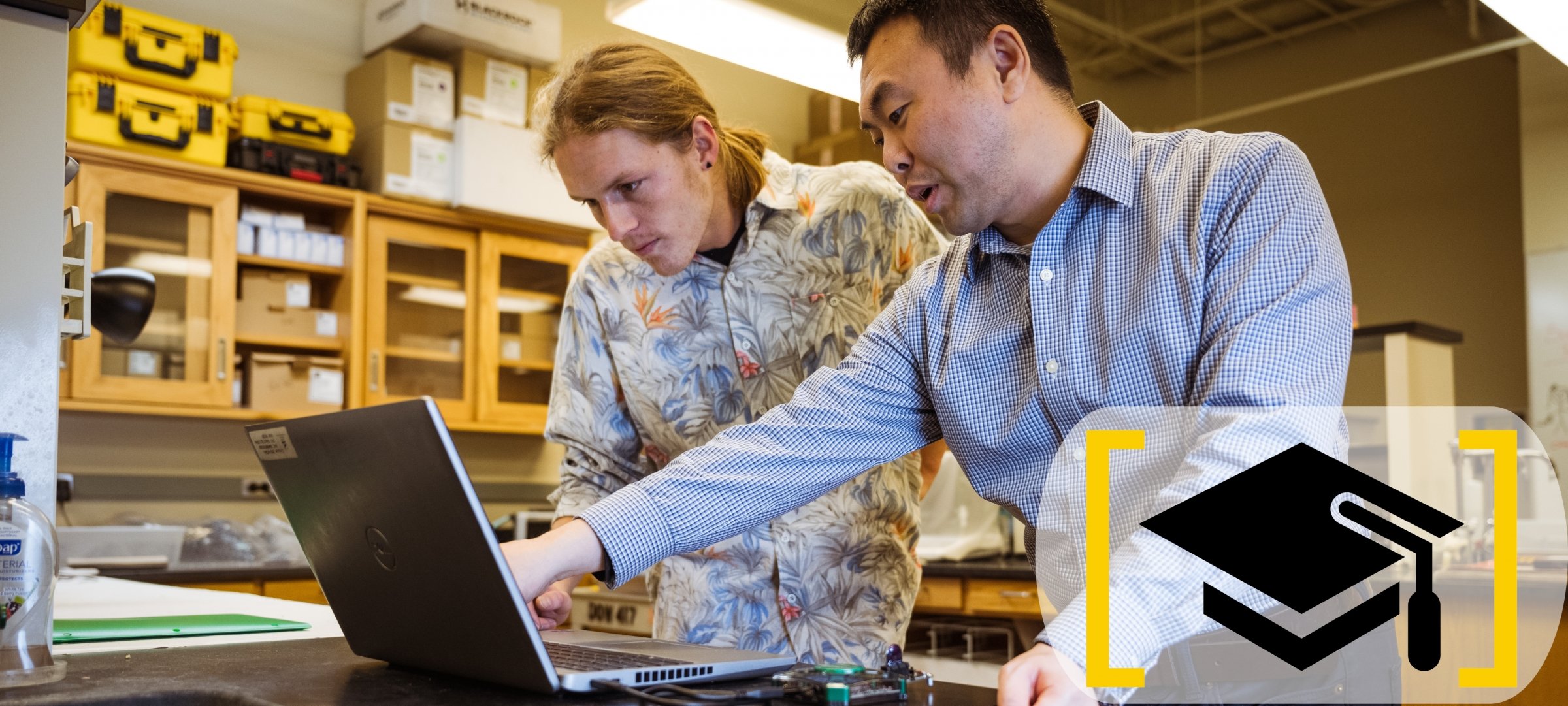 ICC member Hongyu An discusses research on a laptop in a research lab with an MTU student