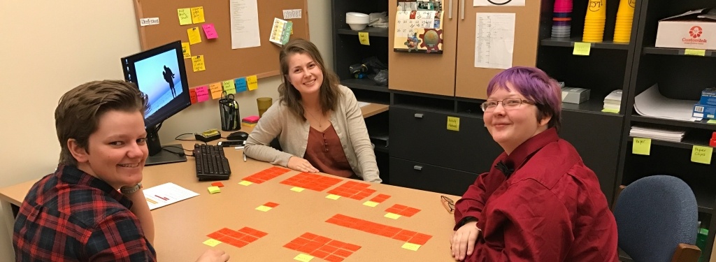 A mixture of students and staff sit around a table