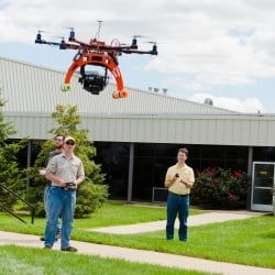 Two men operate a small drone.