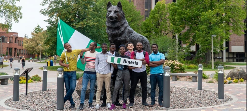 Community with flag in front of the husky statue