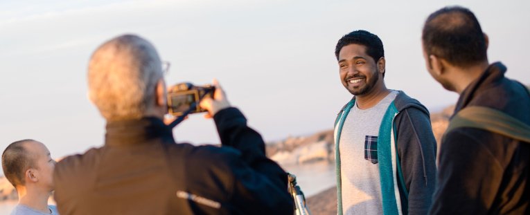 International student being photographed at a beach.