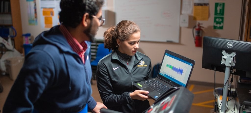 Researcher with laptop, participant on treadmill