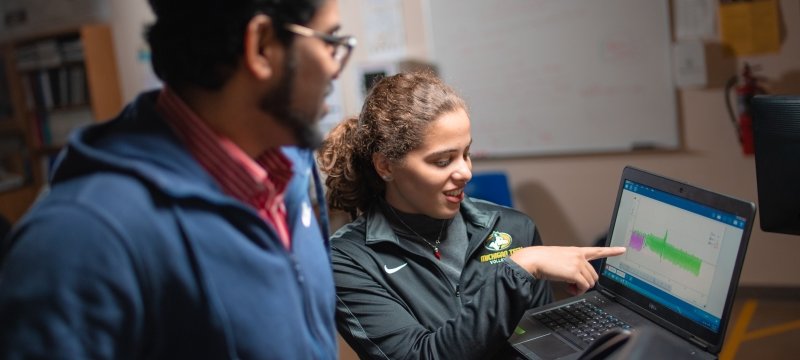 Students looking a results of a test on a laptop