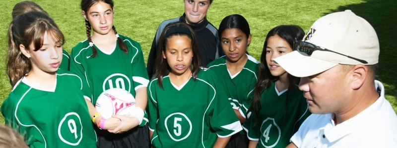 Coach instructing a youth soccer team.