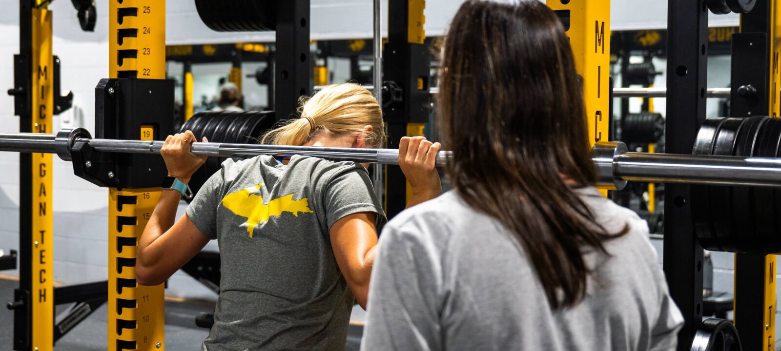 Coach instructing a weight lifter.