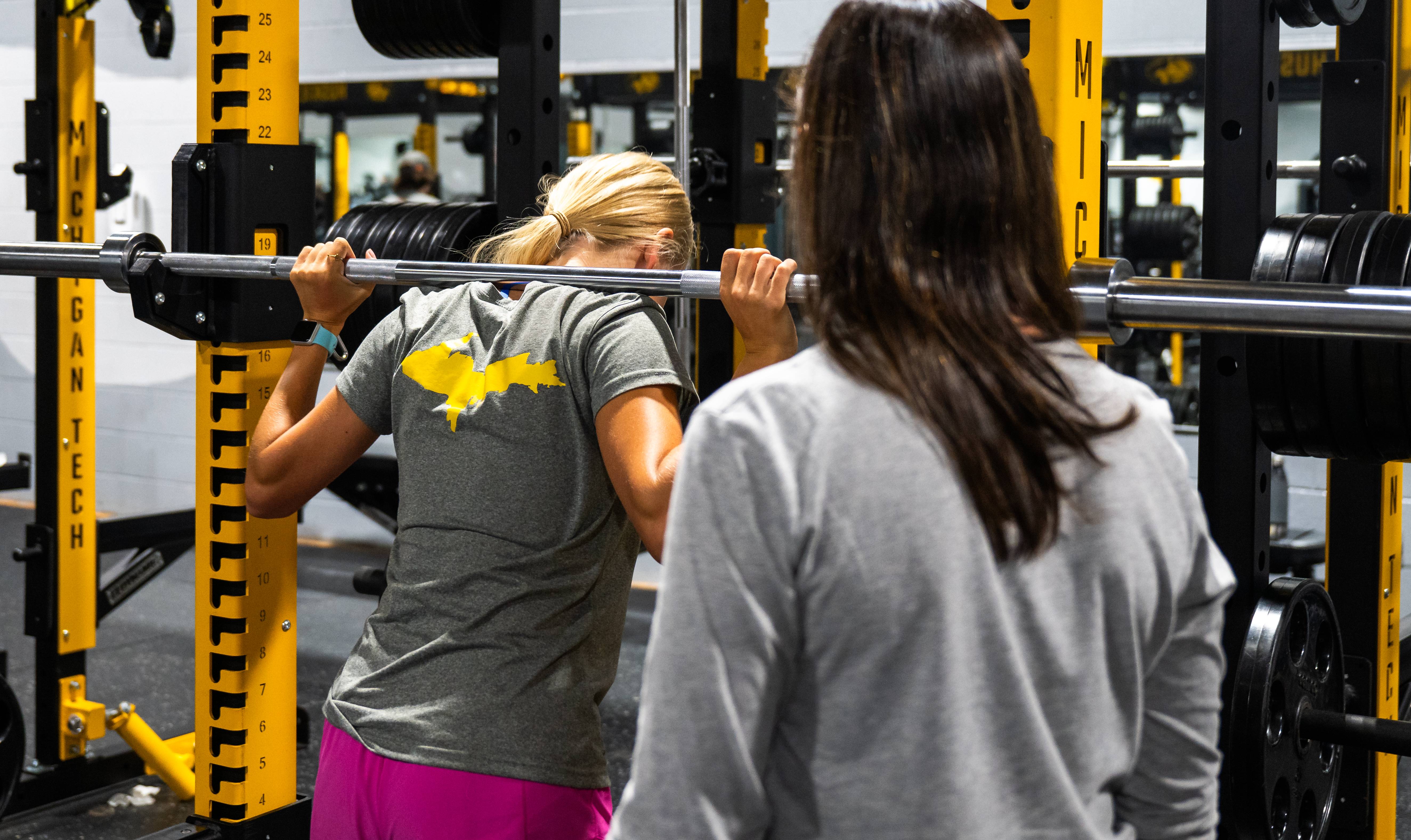 Coach instructing a weight lifter.