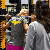 Student lifting weights with coach