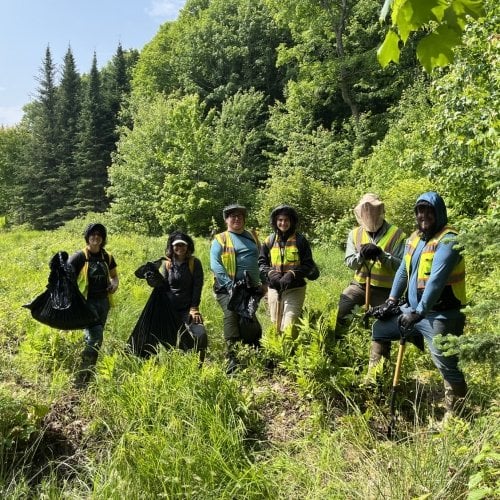 Crew holding bags of plants