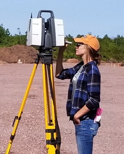 Student looking into surveying equipment