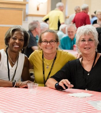 Three alumnae sitting at a table.