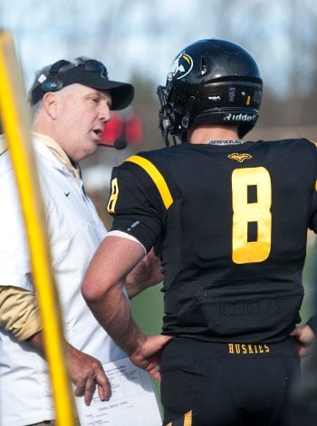 Coach Kearly talking to a player on the sidelines.