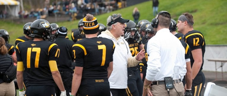 Coach Kearly talking to the team on the sidelines.