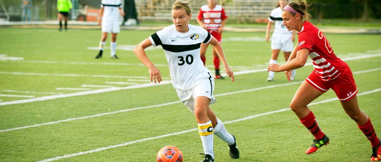 Jess Splittgerber dribbling the ball down the field while an opponent tries to steal it..