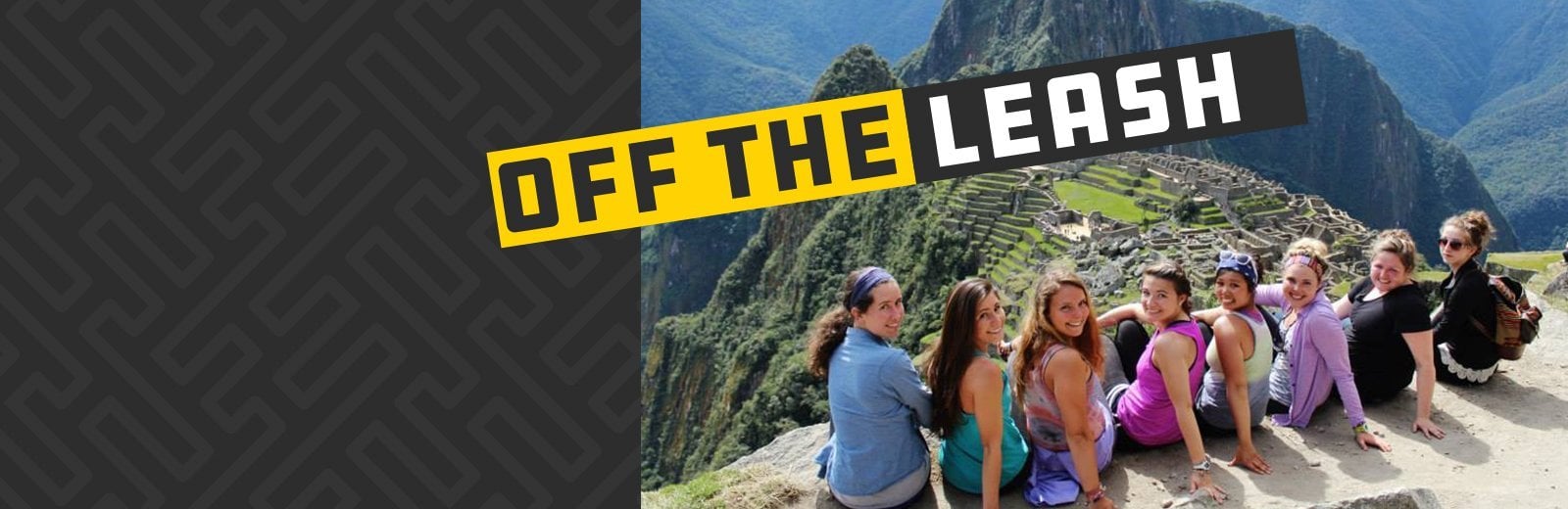 Students sitting on a wall overlooking mountains.