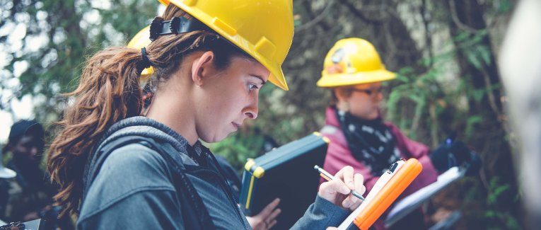 Female forestry students work in the field.